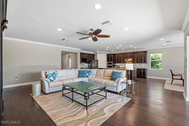 living area featuring visible vents, baseboards, dark wood-style floors, and ornamental molding