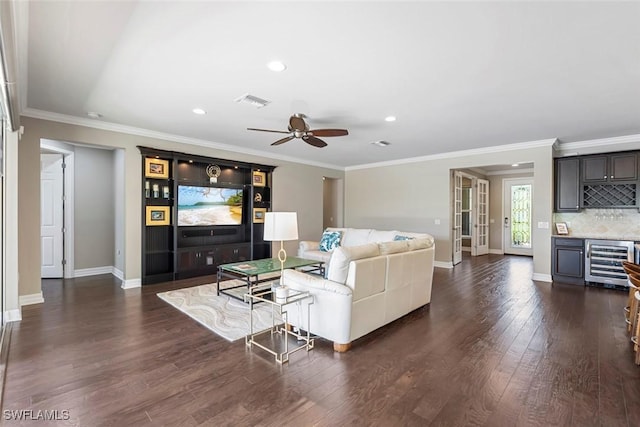 living room featuring wine cooler, a dry bar, dark wood finished floors, and ornamental molding