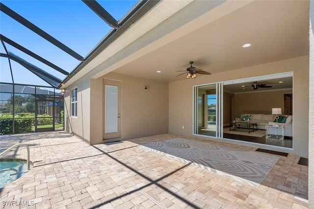 view of patio / terrace featuring glass enclosure, a pool, and a ceiling fan