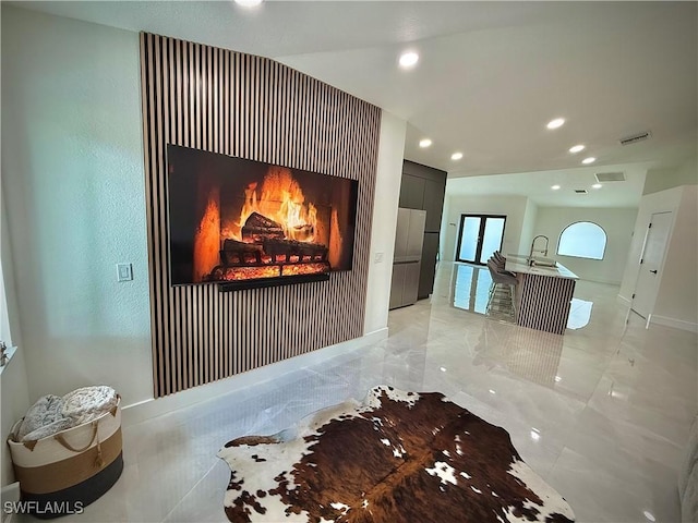 corridor with recessed lighting, marble finish floor, baseboards, and a sink