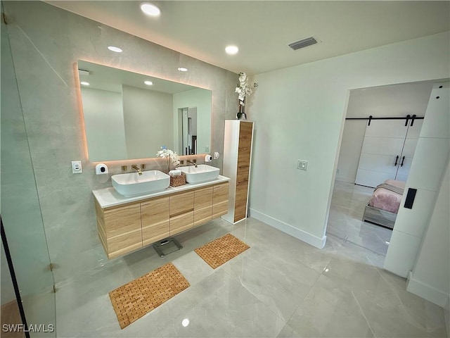 bathroom featuring double vanity, baseboards, visible vents, and a sink