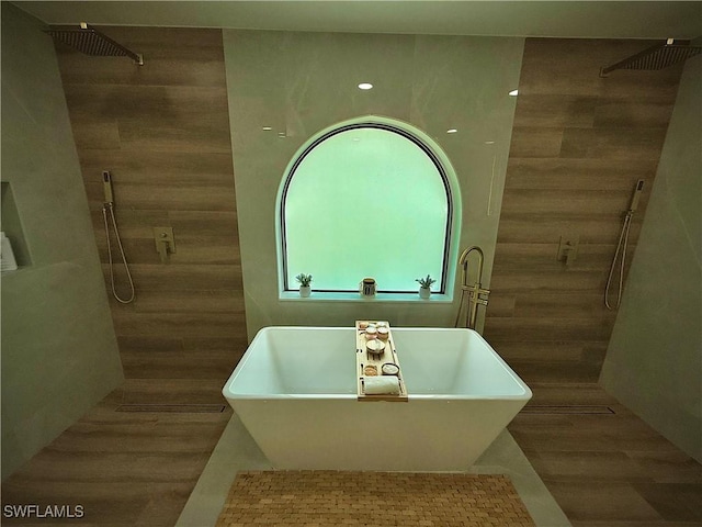 full bathroom featuring a sink, tile walls, a freestanding tub, and walk in shower