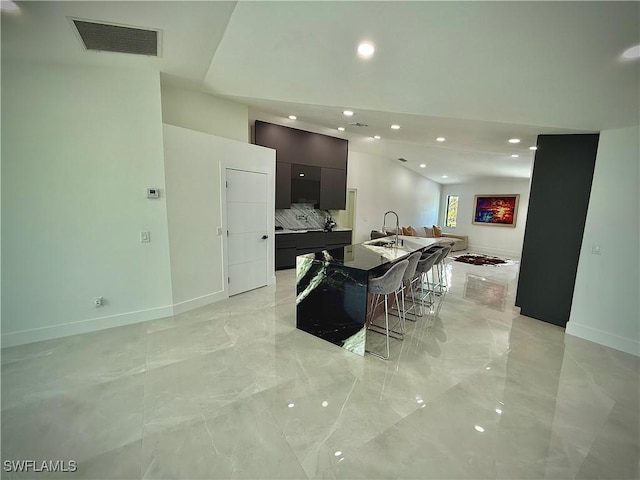 kitchen with visible vents, open floor plan, a center island with sink, marble finish floor, and modern cabinets