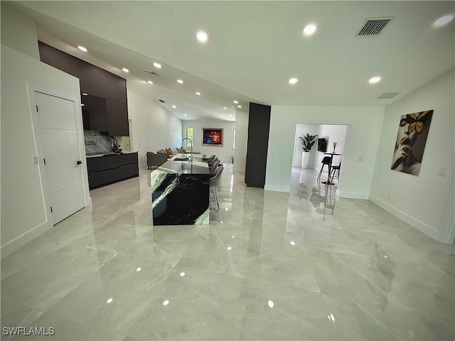 kitchen featuring visible vents, marble finish floor, modern cabinets, and open floor plan