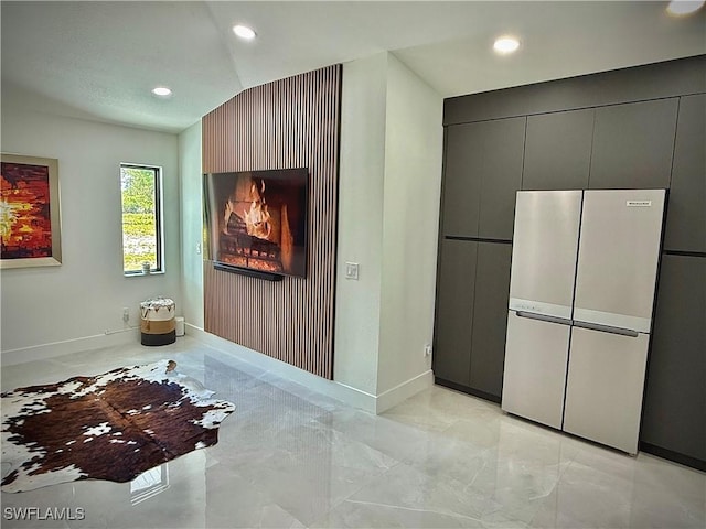corridor featuring recessed lighting, marble finish floor, baseboards, and lofted ceiling