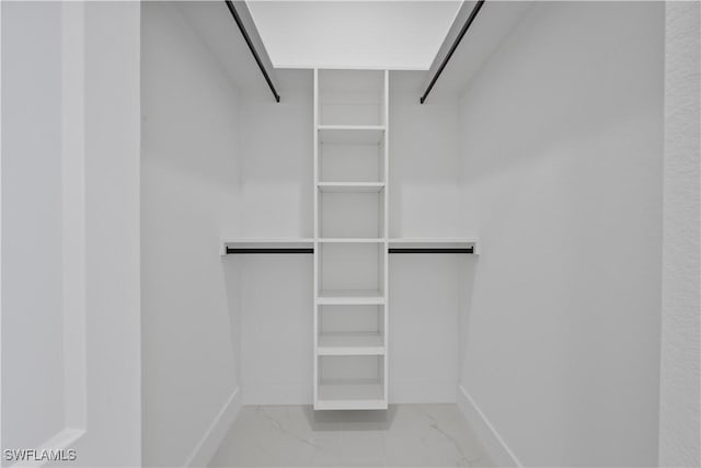 walk in closet featuring marble finish floor