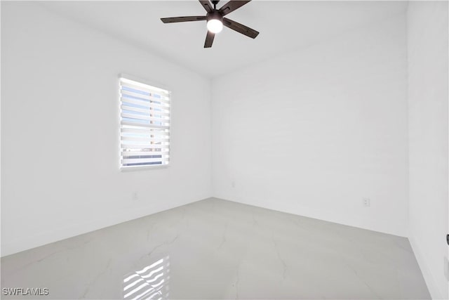 unfurnished room featuring marble finish floor and ceiling fan