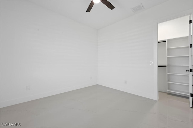 unfurnished bedroom with a spacious closet, visible vents, and baseboards