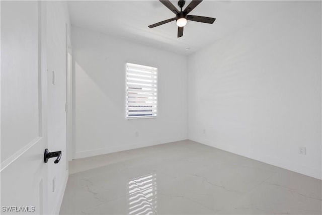 unfurnished room featuring marble finish floor and a ceiling fan