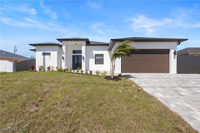 119 Kismet Pkwy E, Cape Coral, FL 33909 - prairie-style house with fence, stucco siding, an attached garage, and decorative driveway