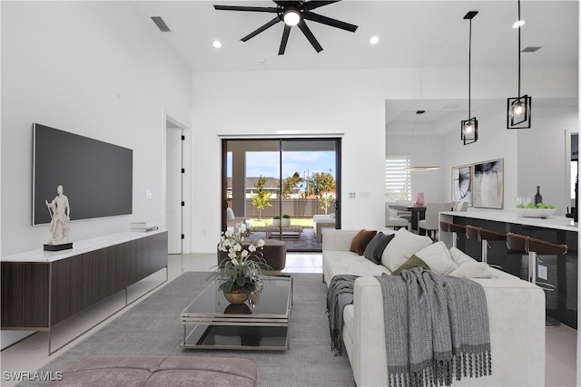 living room featuring recessed lighting, visible vents, a towering ceiling, and ceiling fan