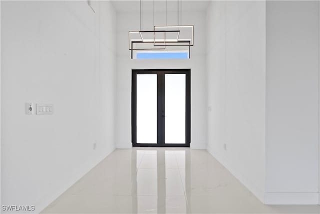 unfurnished room featuring french doors and marble finish floor