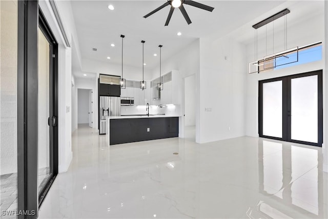 kitchen with modern cabinets, decorative light fixtures, french doors, appliances with stainless steel finishes, and light countertops