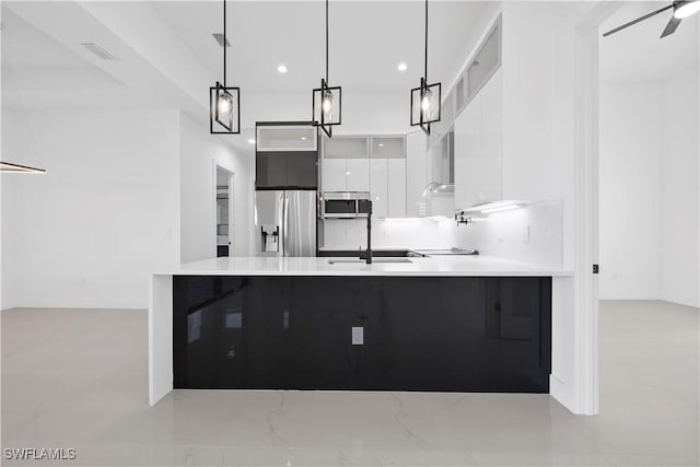 kitchen with visible vents, a peninsula, appliances with stainless steel finishes, white cabinetry, and modern cabinets