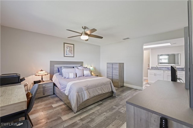 bedroom featuring visible vents, a ceiling fan, wood finished floors, connected bathroom, and baseboards