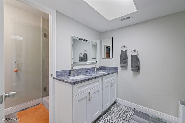 bathroom featuring a sink, visible vents, baseboards, and a stall shower