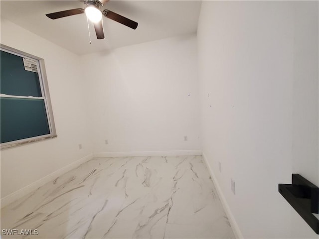 unfurnished room featuring marble finish floor, baseboards, and ceiling fan