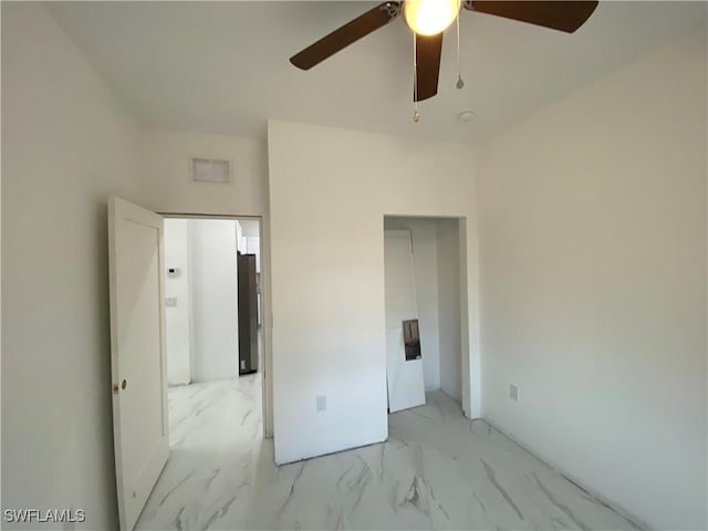 unfurnished bedroom with visible vents, marble finish floor, a ceiling fan, and refrigerator