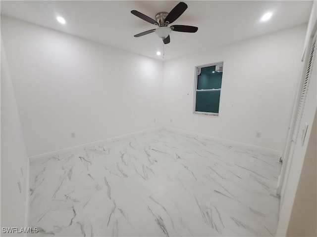 spare room with ceiling fan, recessed lighting, marble finish floor, and baseboards