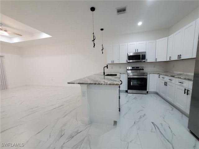 kitchen with visible vents, appliances with stainless steel finishes, a peninsula, marble finish floor, and white cabinetry