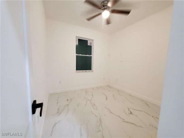 empty room featuring marble finish floor, baseboards, and ceiling fan