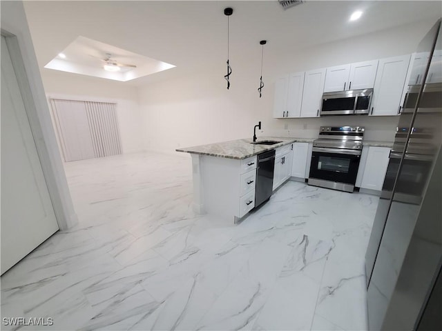 kitchen with white cabinetry, a peninsula, marble finish floor, black appliances, and a sink