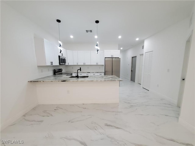 kitchen featuring visible vents, a sink, white cabinetry, stainless steel appliances, and a peninsula