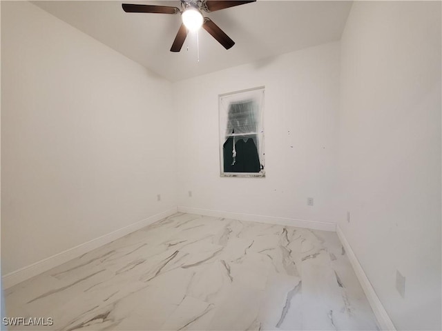 empty room featuring baseboards, marble finish floor, and ceiling fan