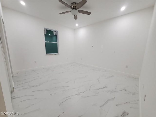 empty room featuring recessed lighting, marble finish floor, and baseboards