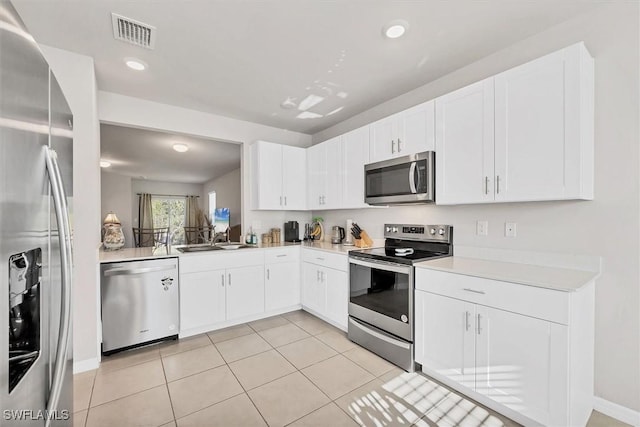 kitchen with light tile patterned floors, visible vents, a sink, light countertops, and appliances with stainless steel finishes