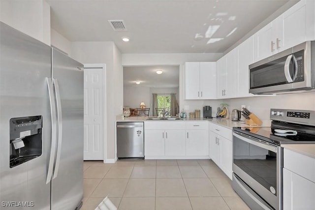 kitchen featuring visible vents, a sink, stainless steel appliances, light tile patterned flooring, and light countertops