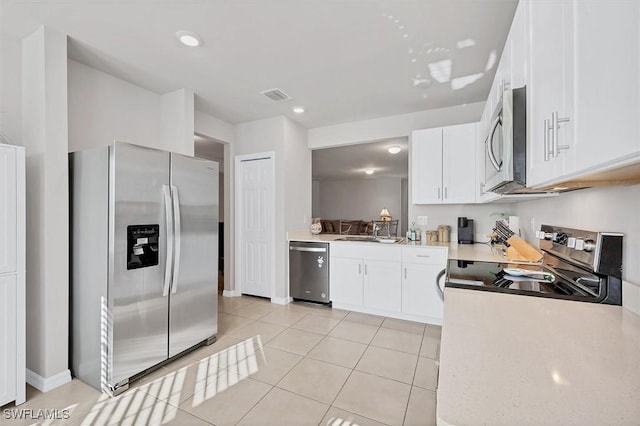 kitchen with visible vents, light countertops, light tile patterned floors, white cabinets, and stainless steel appliances