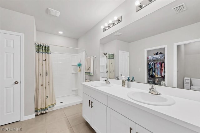 bathroom with tile patterned floors, visible vents, a stall shower, and a sink