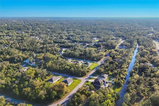 bird's eye view with a wooded view