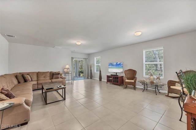 living room with light tile patterned floors, baseboards, and visible vents