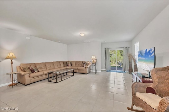 living area featuring light tile patterned floors and baseboards