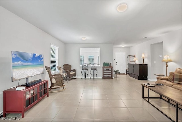 tiled living room featuring visible vents and baseboards