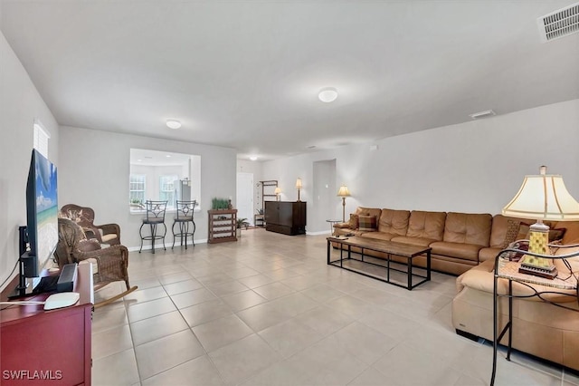 living area featuring light tile patterned floors, baseboards, and visible vents