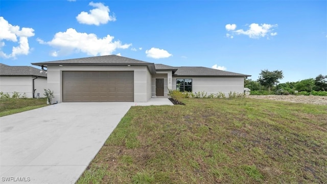 prairie-style home featuring a front yard, concrete driveway, a garage, and stucco siding