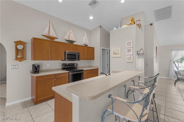 kitchen featuring light countertops, visible vents, arched walkways, and stainless steel appliances