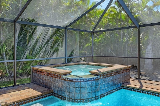 outdoor pool with a lanai and an in ground hot tub