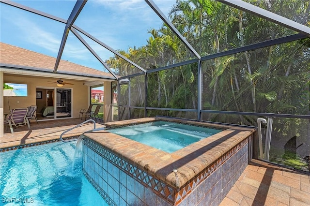 pool featuring glass enclosure, a patio, and an in ground hot tub