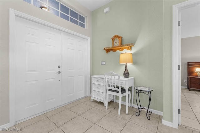 entrance foyer featuring light tile patterned floors and baseboards