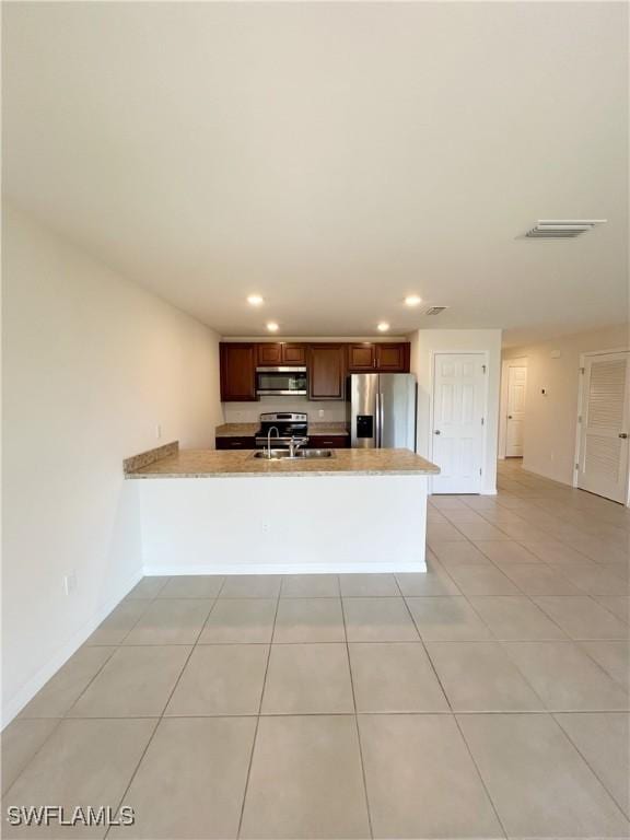 kitchen with visible vents, a peninsula, recessed lighting, stainless steel appliances, and light countertops