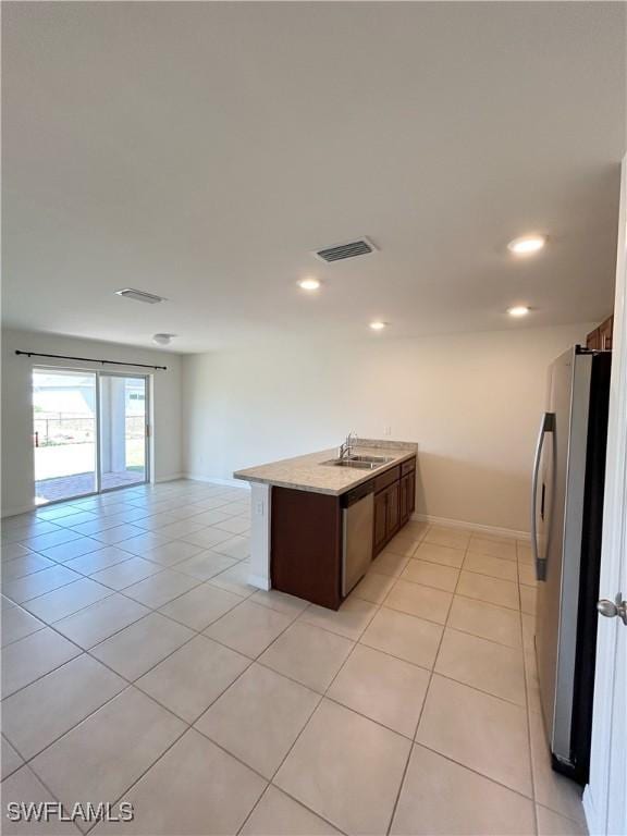 kitchen with visible vents, open floor plan, light tile patterned floors, appliances with stainless steel finishes, and a sink