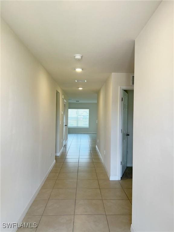 hall with light tile patterned floors and baseboards