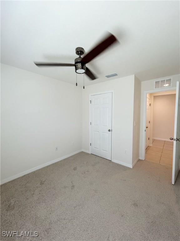 unfurnished bedroom with visible vents, carpet flooring, and baseboards