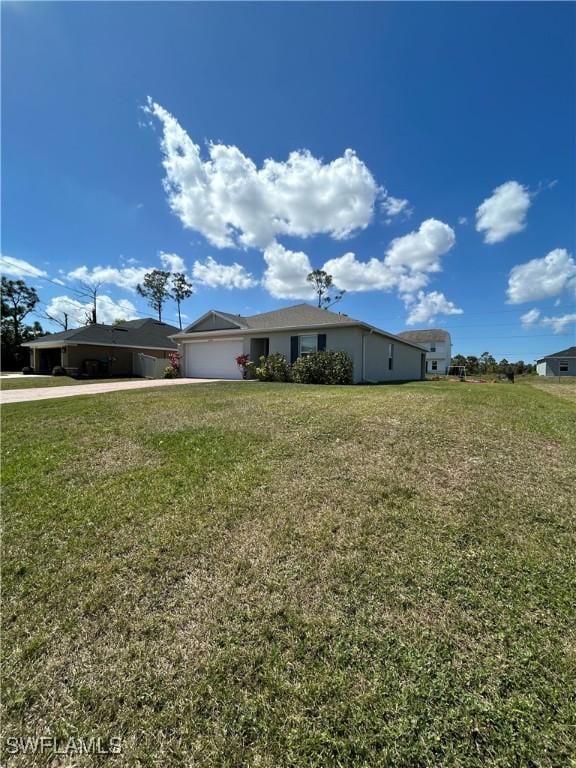 view of front of home featuring driveway, a front lawn, and an attached garage