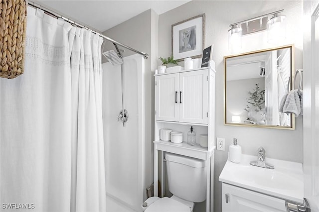 bathroom featuring toilet, vanity, and a shower with shower curtain