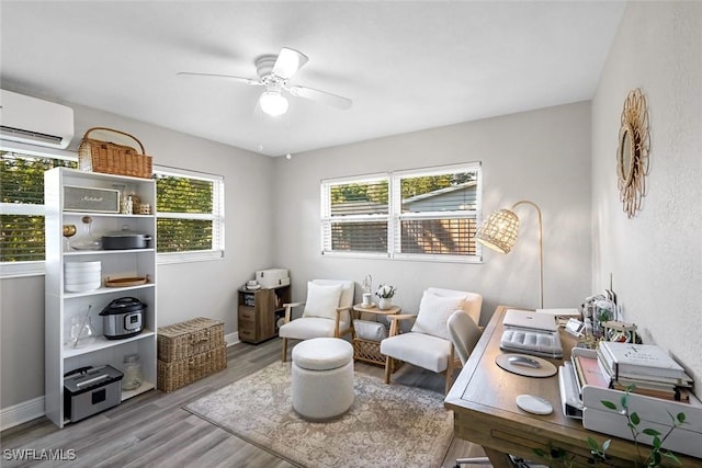 office area featuring baseboards, an AC wall unit, ceiling fan, and wood finished floors